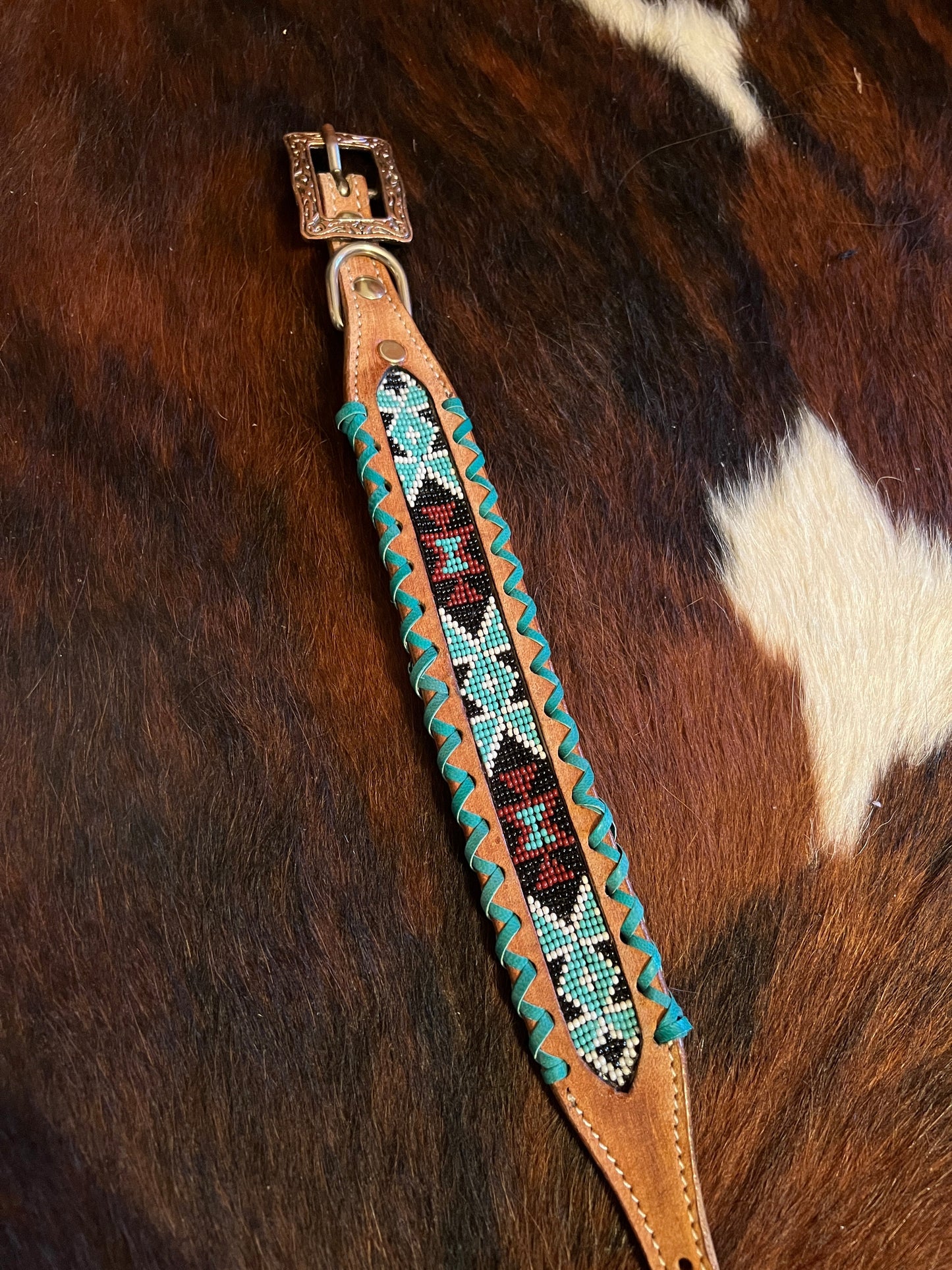 Genuine leather dog collar with teal, white, and burgundy beaded inlay design, a rawhide wrapped edge