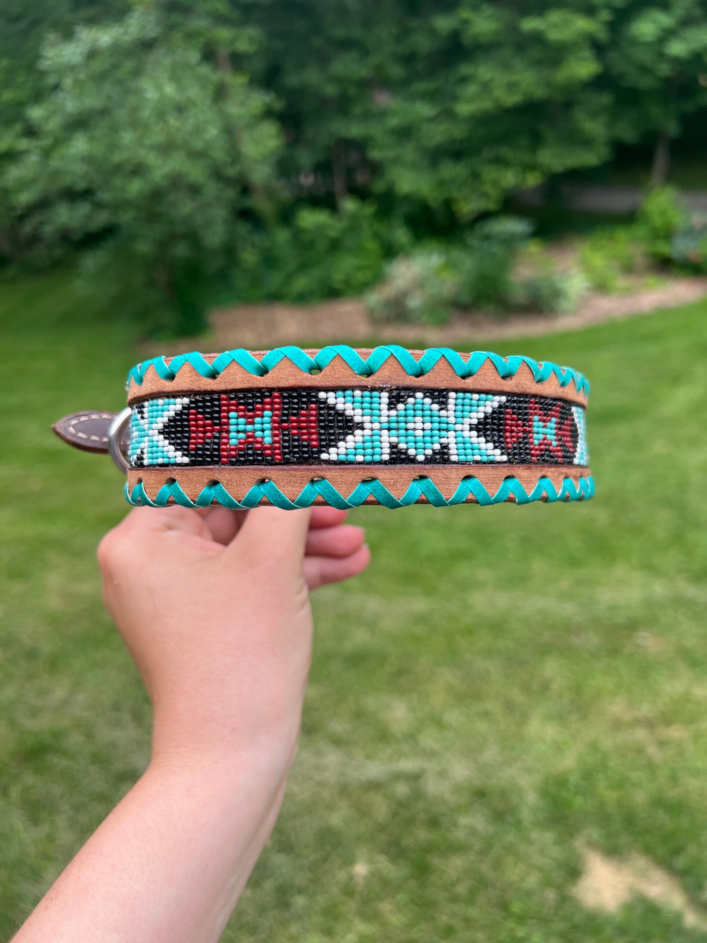 Genuine leather dog collar with teal, white, and burgundy beaded inlay design, a rawhide wrapped edge
