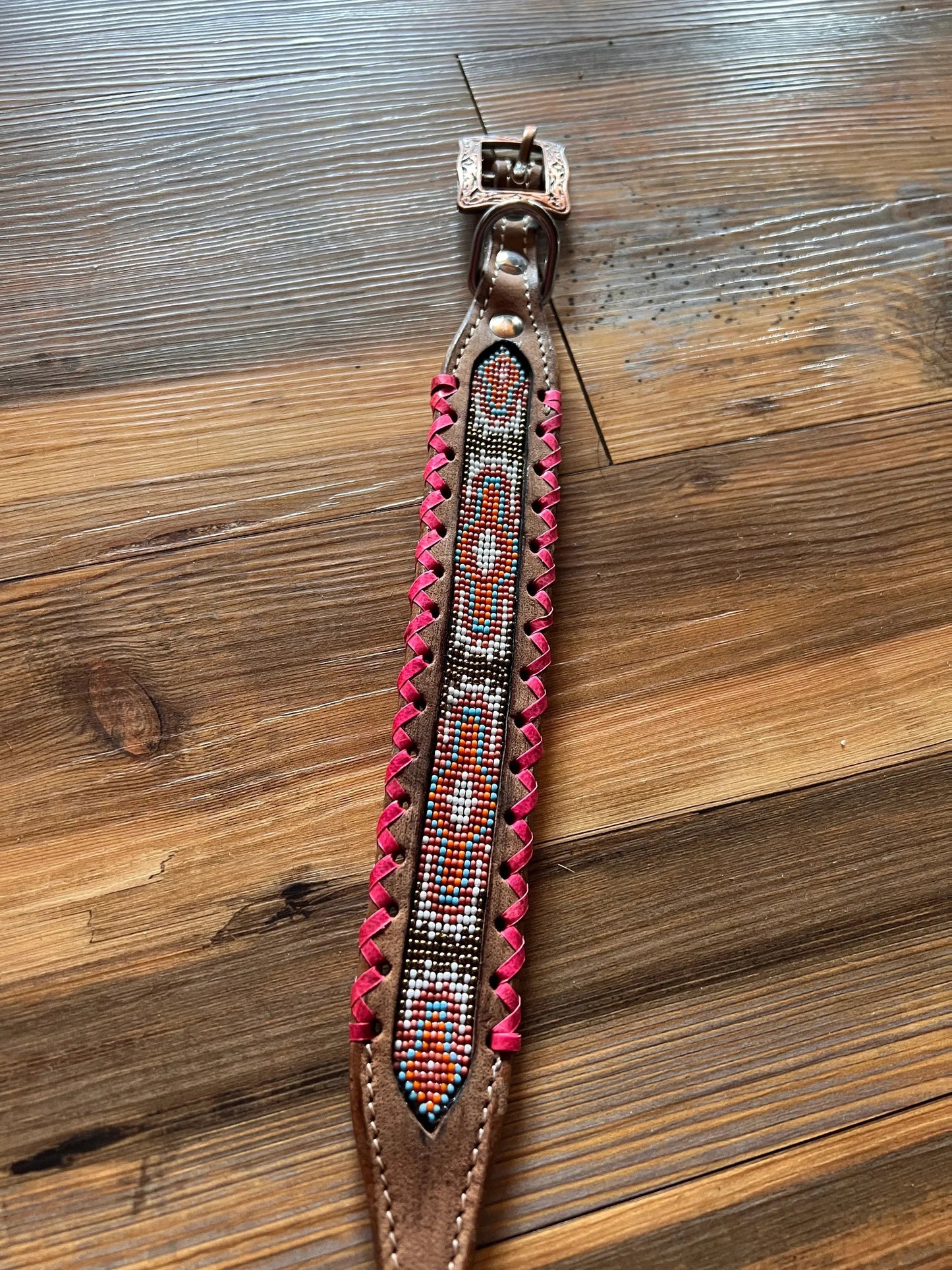 Genuine leather dog collar with pink, white, and gold southwest beaded inlay design, a rawhide wrapped edge