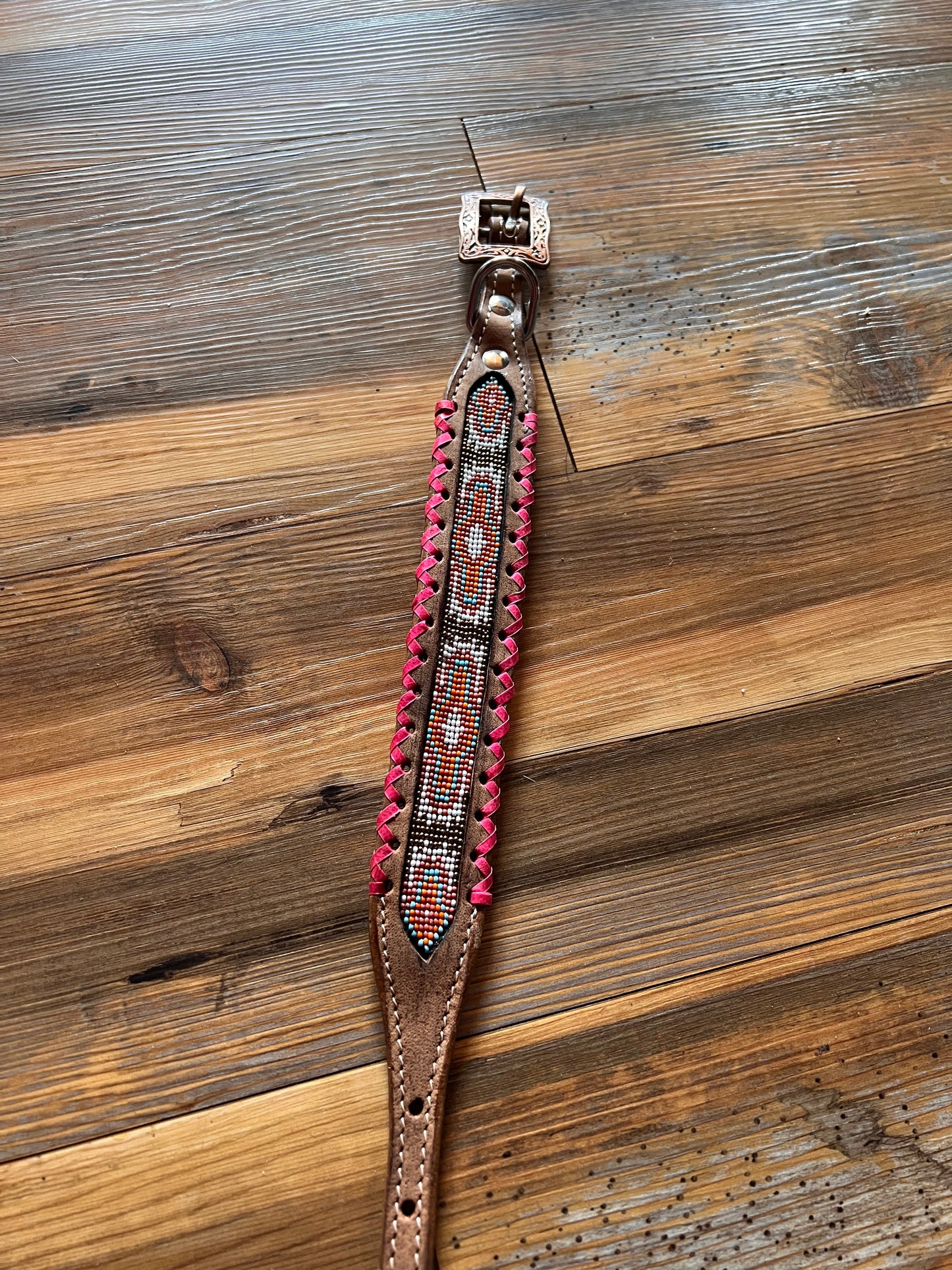 Genuine leather dog collar with pink, white, and gold navajo beaded inlay design, a rawhide wrapped edge